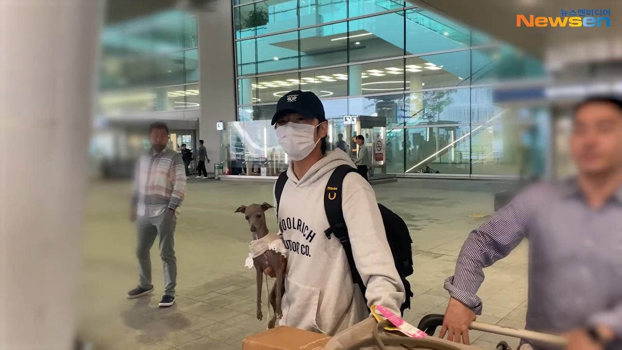 19日宋仲基抱著狗狗現身仁川機場。(圖/翻攝自Newsen YouTube)