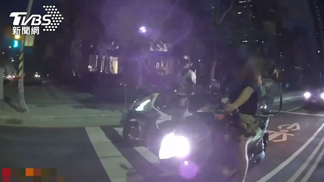 女警趁著停等紅燈時盤查可疑騎士。（圖／TVBS）