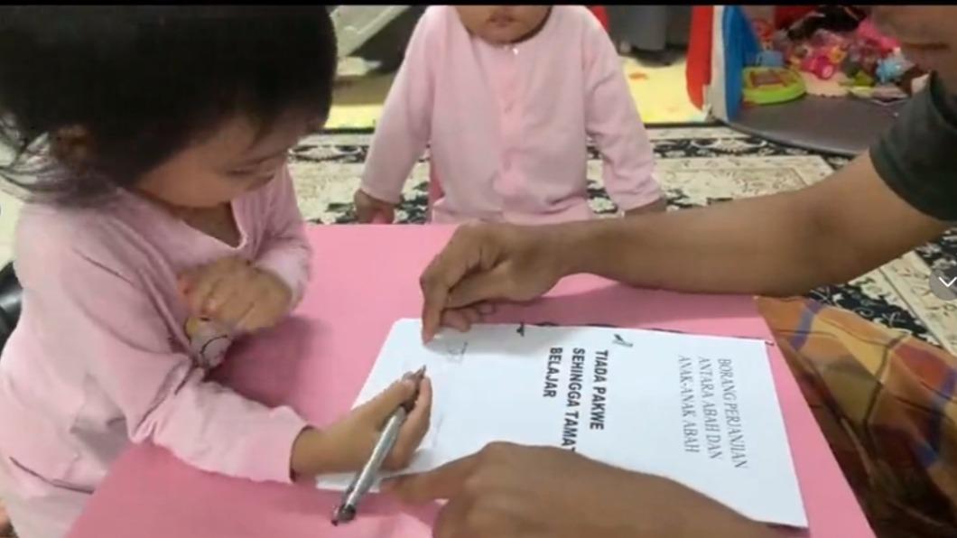 父親細心的向女兒們解釋協議書內容。(圖/翻攝自TikTok @abah_double_sumayyah)