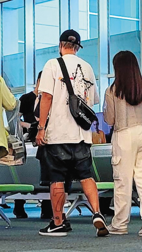 小豬與女助理在機場候機室討論工作行程,還露出左腳的幸運數字刺青。(圖/鏡週刊)