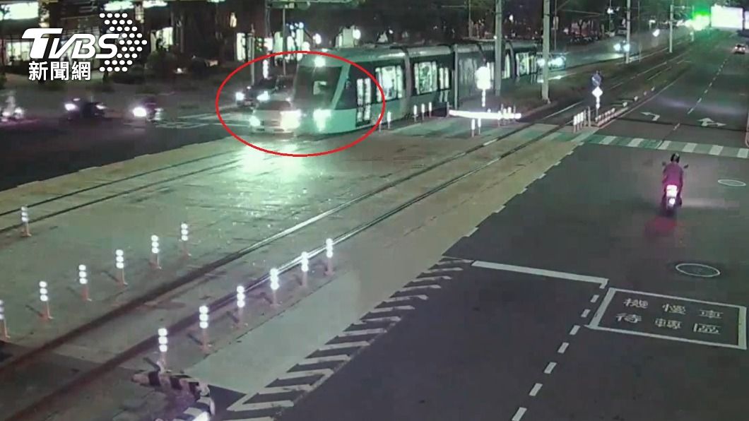 監視器拍下白色賓士車迴轉時不慎撞上輕軌列車。(圖/TVBS)