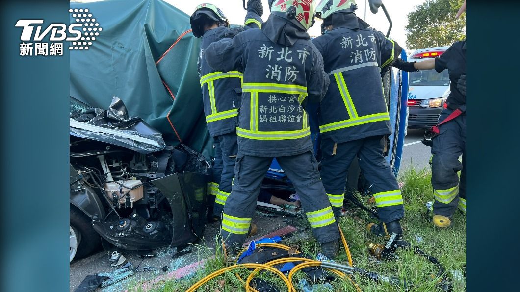 小貨車副駕駛受困車底,大批警消到場救援。(圖/TVBS)