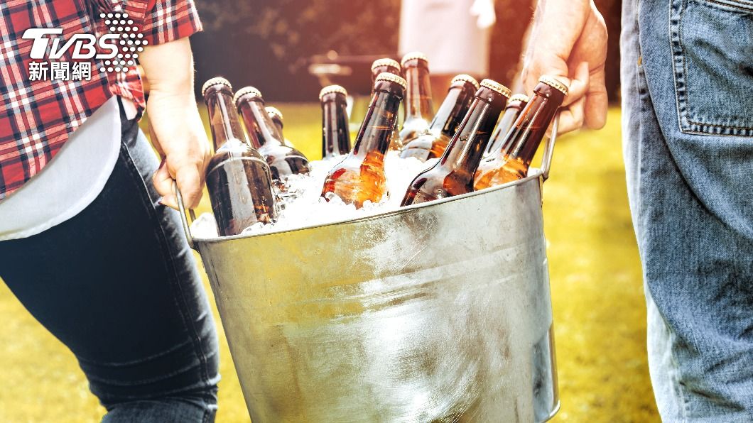 狂歡民眾將啤酒灌入巨蟒口中。(示意圖/Shutterstock達志影像)