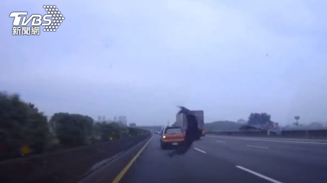 橘色轎車變換線道時，不慎輾壓到其他車輛掉落的輪胎皮。（圖／TVBS）