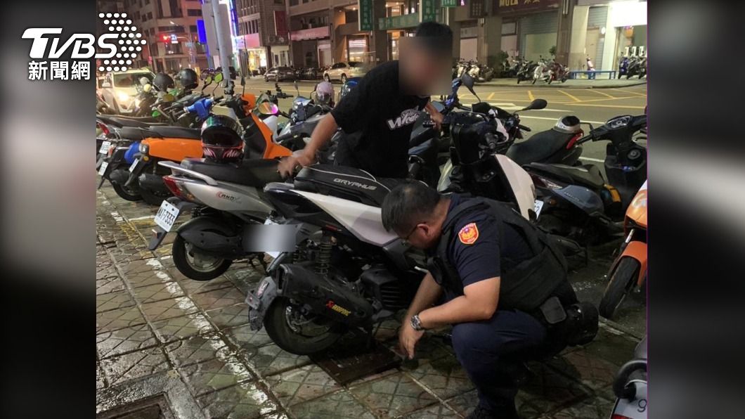 機車中柱兩隻腳都卡水溝蓋，警化身大力士幫脫困。（圖／TVBS）