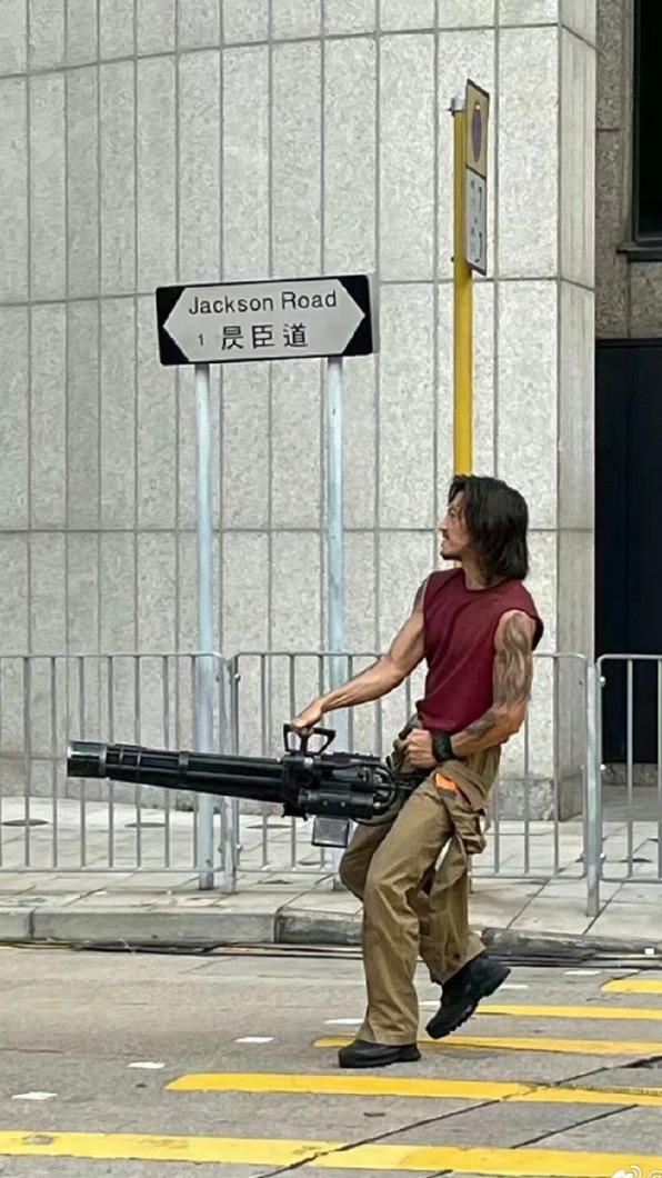 謝霆鋒手拿機關槍正在拍攝的畫面曝光。(圖/翻攝自微博)