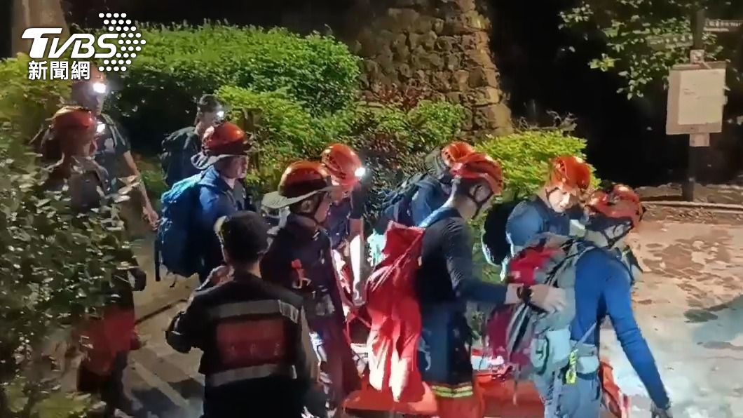 警消將扭傷腳踝的婦人搬運下山。(圖/TVBS)