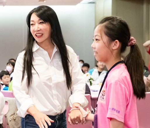 麗彤生醫董事長張麗綺(左)與嘉義縣國小學童開心互動