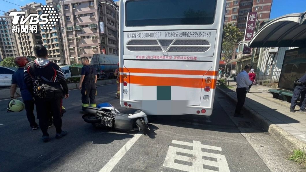 機車騎士撞上公車後受困車底，警消到場搶救。（圖／TVBS）
