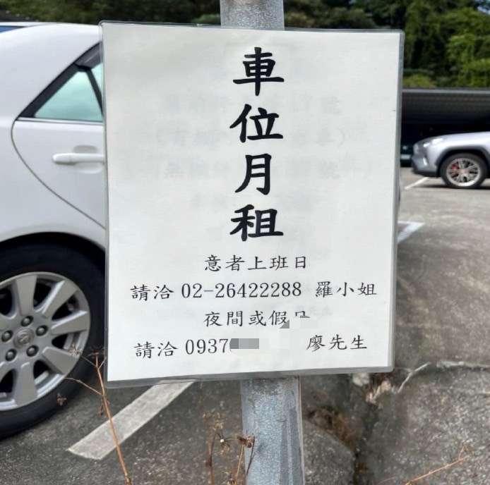 該停車場的入口處貼有車位出租公告，聯絡電話是廖先翔服務處的市內電話號碼。（圖／鏡週刊）
