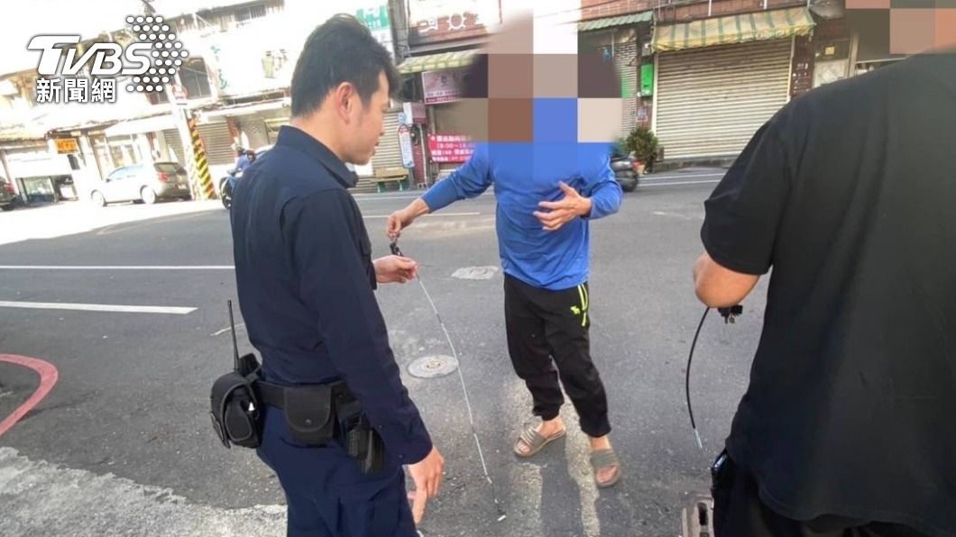 員警將衣架變成長條狀的鐵絲。(圖/TVBS)