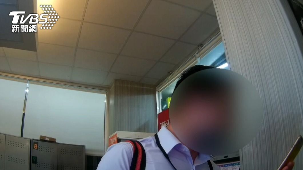 余男拿出手機查看朋友的身分證字號。(圖/TVBS)
