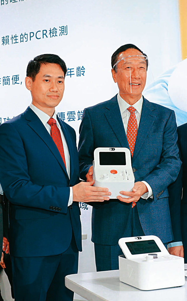 富佳生技開發出「口水機」,投資成立公司的郭台銘(右)也出席記者會,和一旁的廖本揚(左)合影。(翻攝郭台銘臉書)