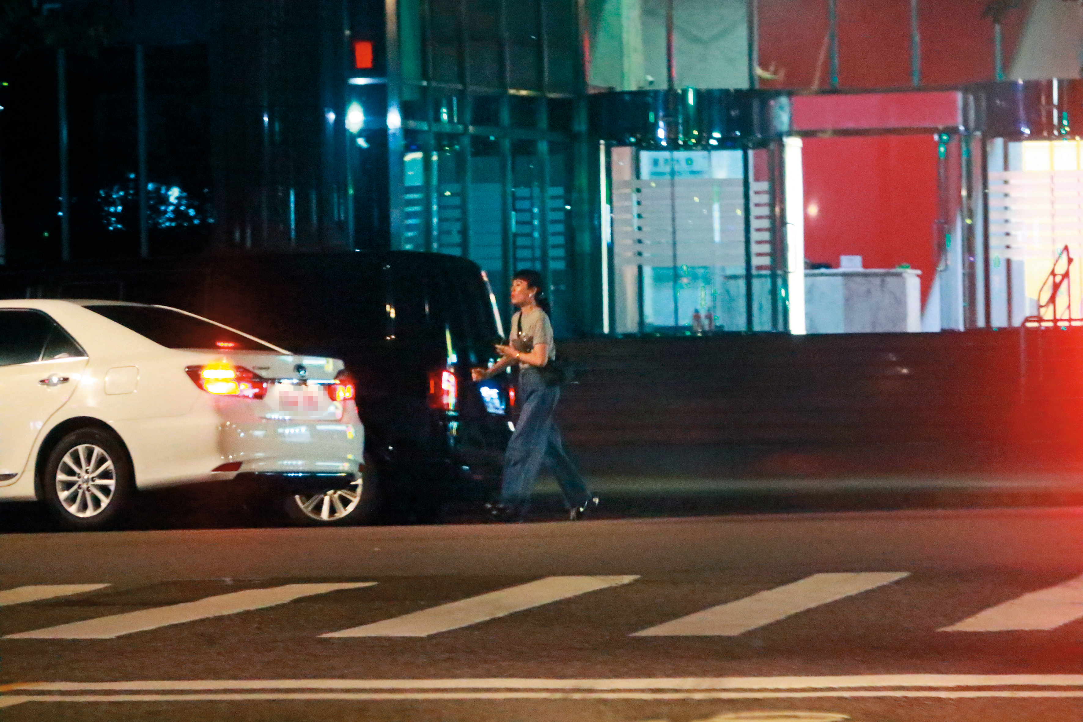 11/8，23：03魏如萱邊喝水邊在路邊耐心等待多元計程車到來，最後搭車回家。（圖／鏡週刊）