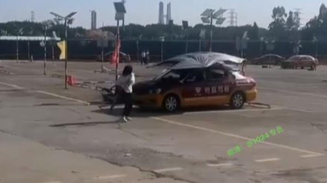 女子疑似因練車頻頻遇上挫折,竟手持方向盤架狂砸教練車。(圖/翻攝自微博)