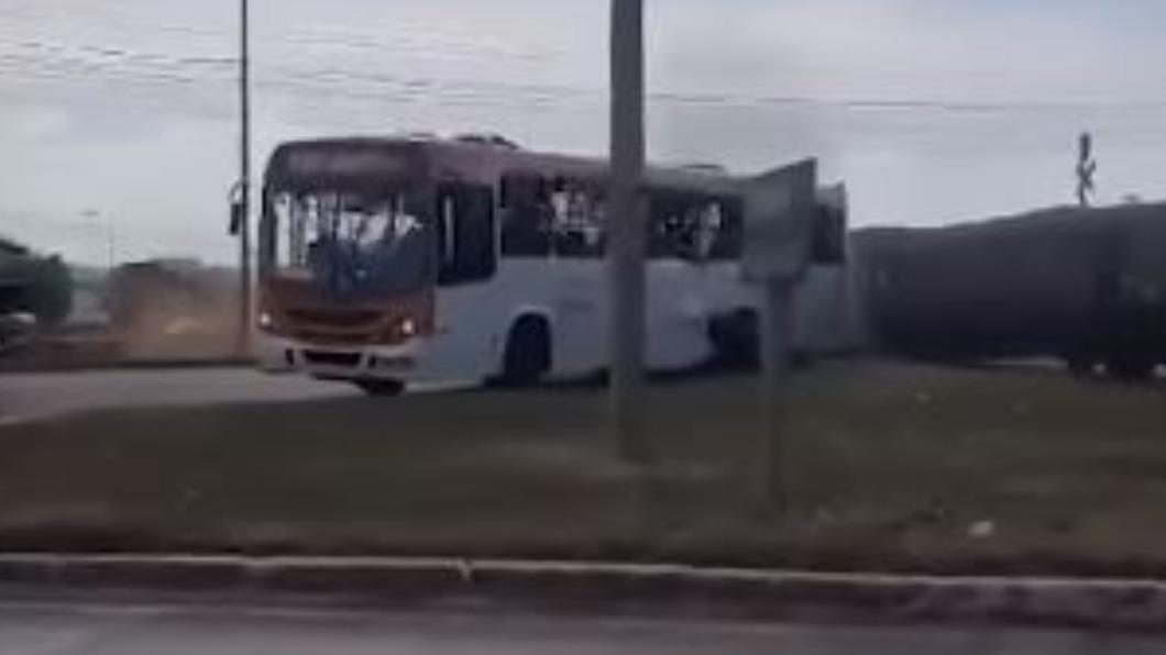 公車卡在平交道上,並被一輛火車高速側撞。(圖/翻攝自X)