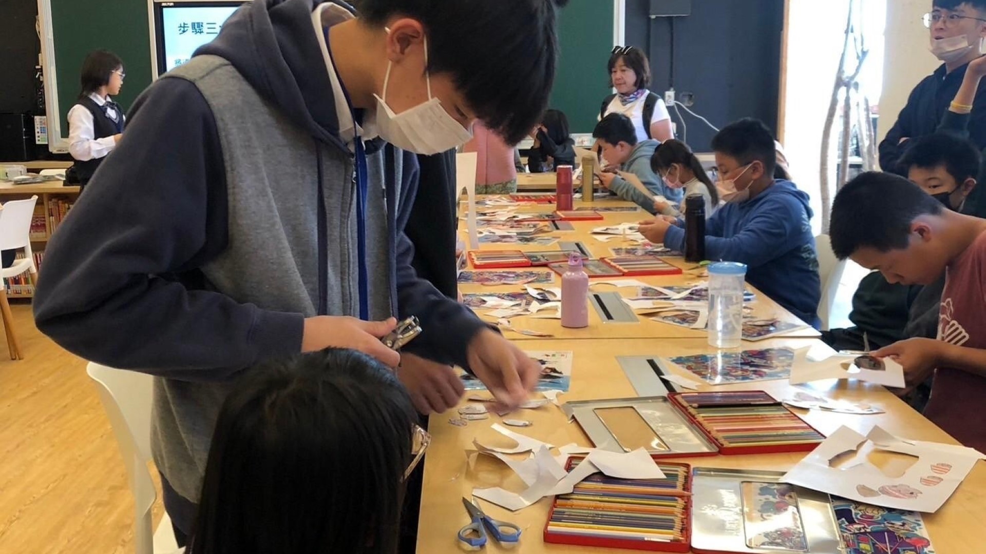 大明高中學生指導梨山國中小學生製作戲偶。(圖/臺中市政府新聞局)