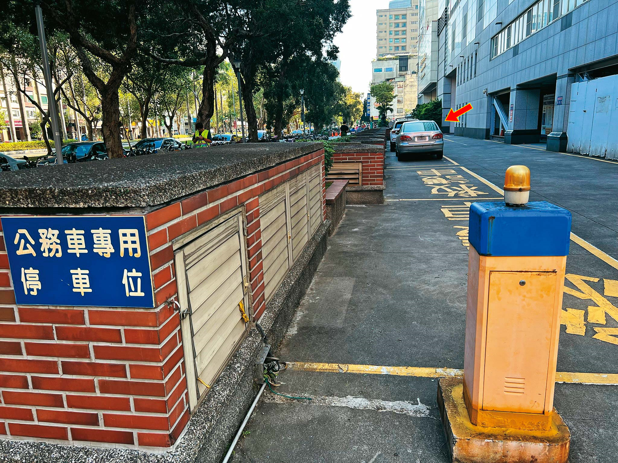 許朝程開車載母親到醫院看診，座車（箭頭處）就大剌剌停在公務車停車區。（圖／鏡週刊）