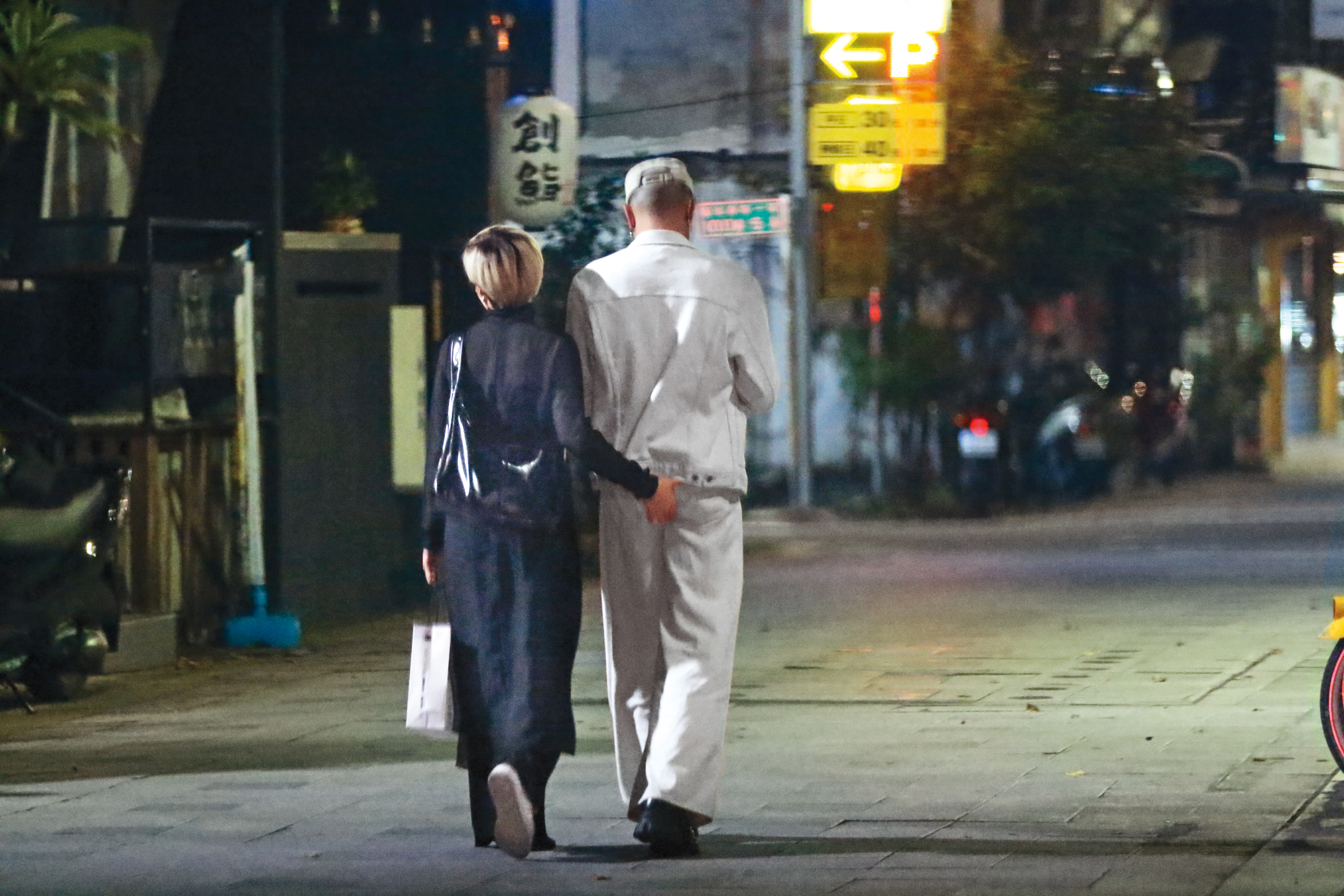 黃宣和經紀人女友Elsie邊走路邊上演抓屁屁戲碼。(圖/鏡週刊)