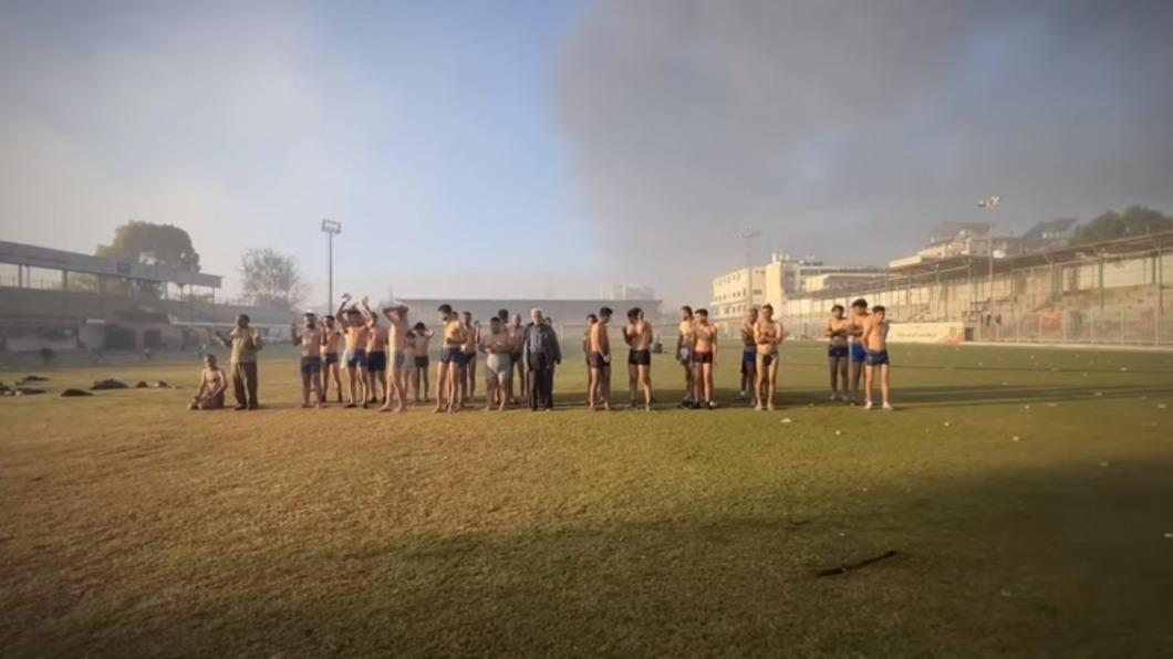 衣物遭脫光的人質被要求舉高雙手並抱頭，其中包含數名男童。（圖／翻攝自「Yosee Gamzoo Letova」YouTube）
