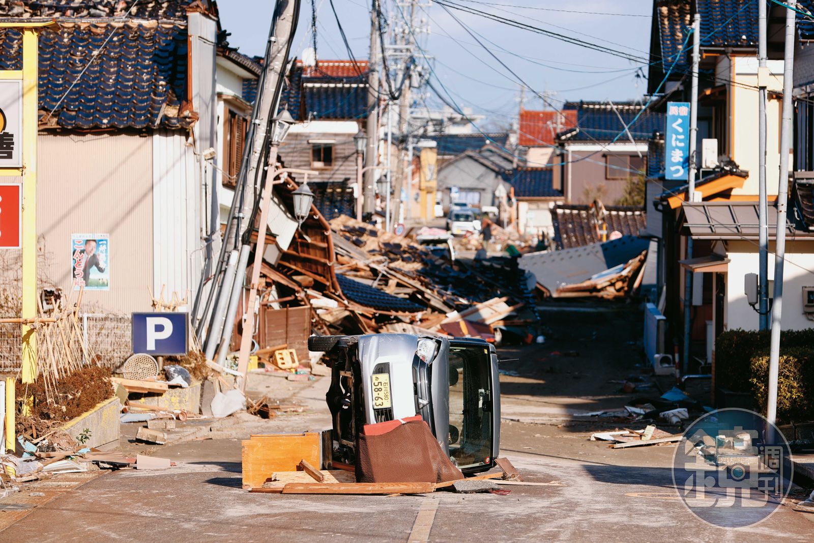 珠洲市在地震發生後,沿海的吾妻町一帶遭受海嘯侵襲,海嘯將一台車子沖倒翻覆在路中央。(圖/鏡週刊)