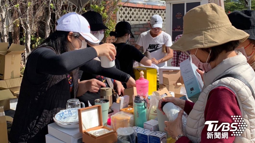民眾將挑選的義賣商品緊抓在手,深怕一放回攤位上,就被其他人挑選走。(圖/TVBS)