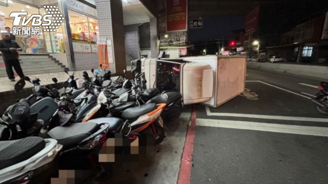 小貨車側翻後撞進停車格,13輛機車被波及。(圖/TVBS)