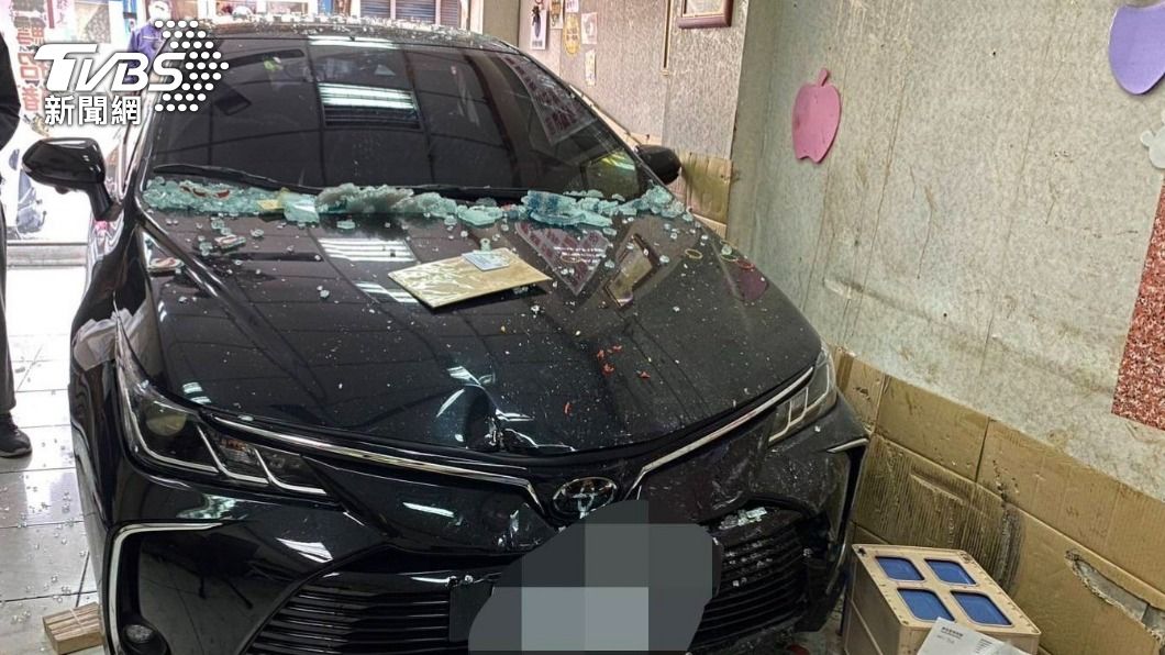 黑色轎車前擋車窗破碎、車頭輕微受損。(圖/TVBS)