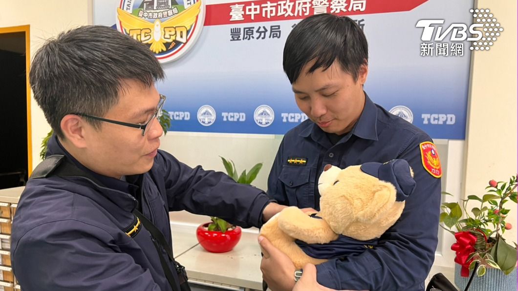 員警向同事學習抱小孩技巧。(圖/TVBS)