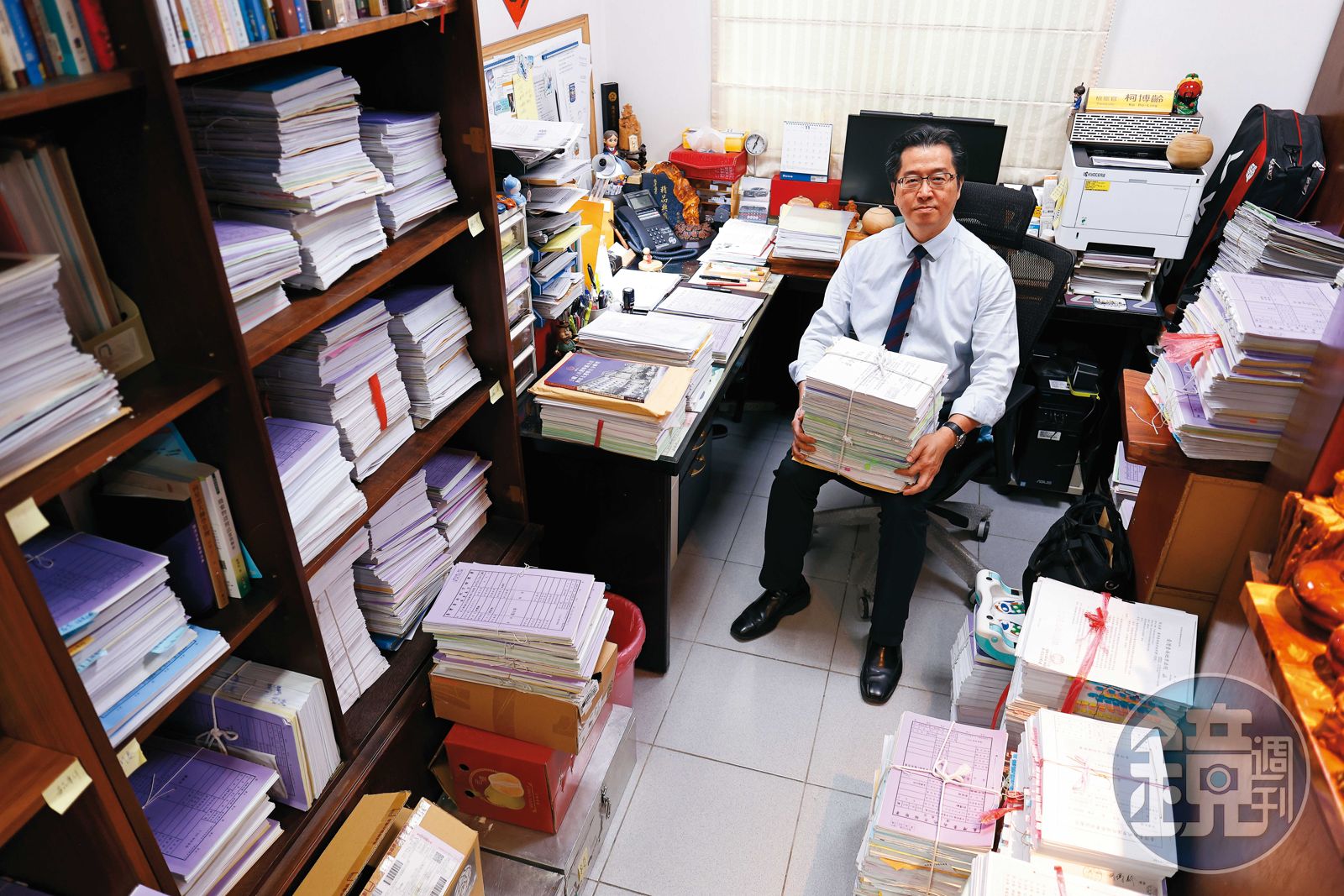 柯博齡的辦公室堆滿一疊疊卷宗，案件難度不一，以他手上為例，光是一件案子的卷宗就如此之多。（圖／鏡週刊）