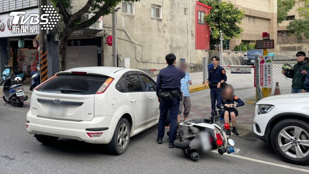 女警膝蓋受傷坐在路邊。(圖/TVBS)
