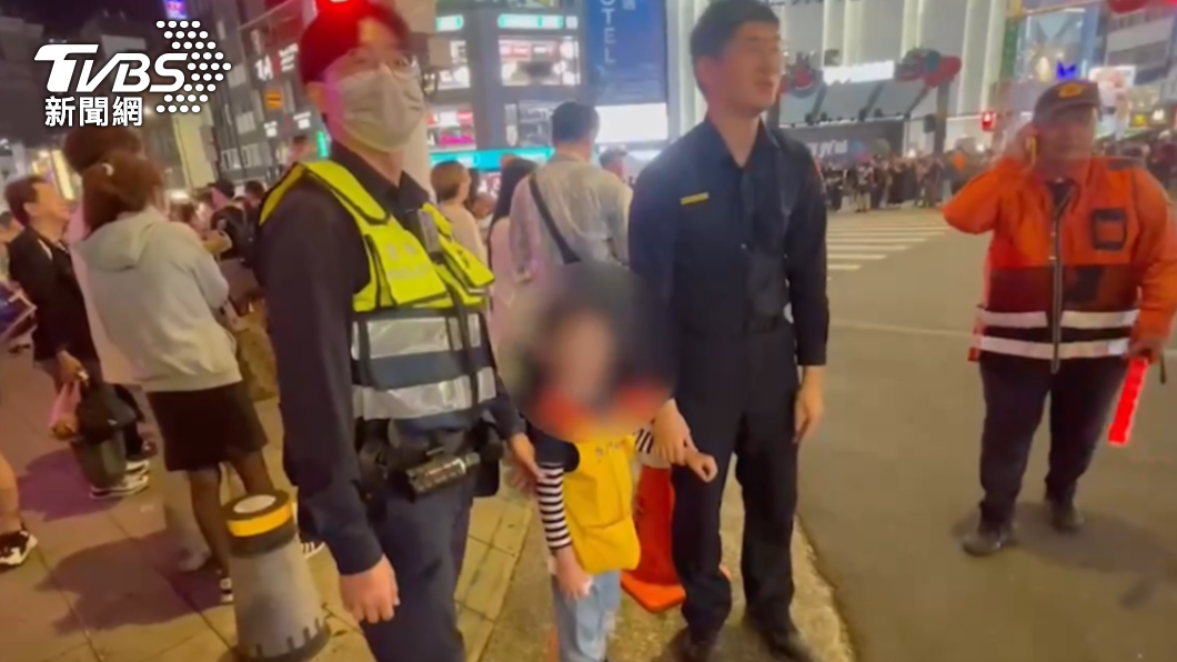 兩名員警陪男童站在廣場前找尋媽媽。(圖/TVBS)