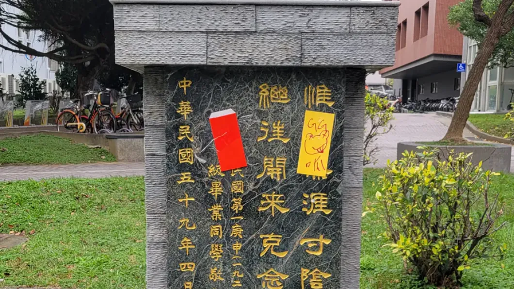 紀念校友的紀念碑上也被貼上符咒與紅包。(圖/翻攝自Dcard)