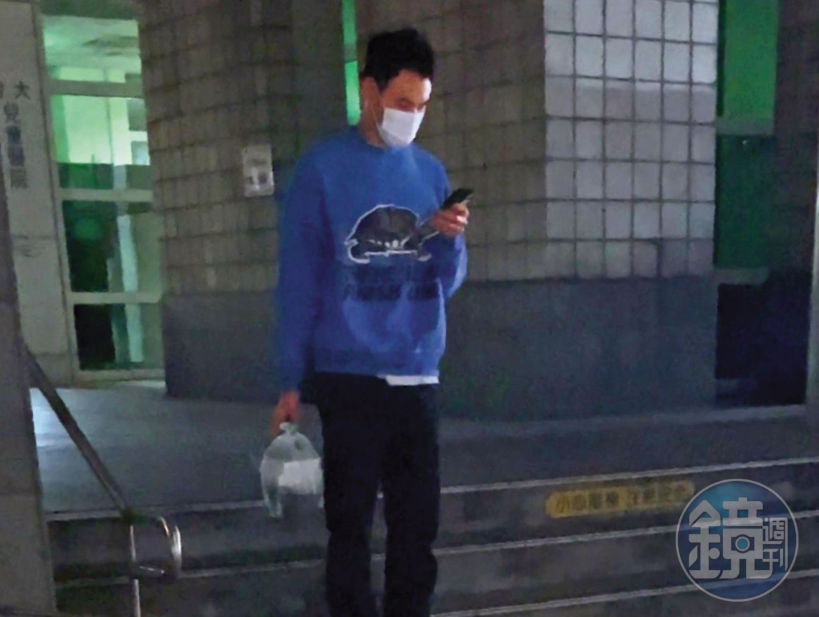 3/20 19:11,提著一袋外送餐食的阮經天站在醫院附近,等待著另一份外送到來。(圖/鏡週刊)