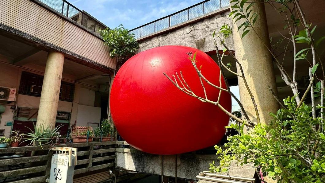 民眾搶看紅球卡進兩棟建築相通的人行天橋上充氣畫面。(圖/翻事自台南式 Tainan Style臉書)