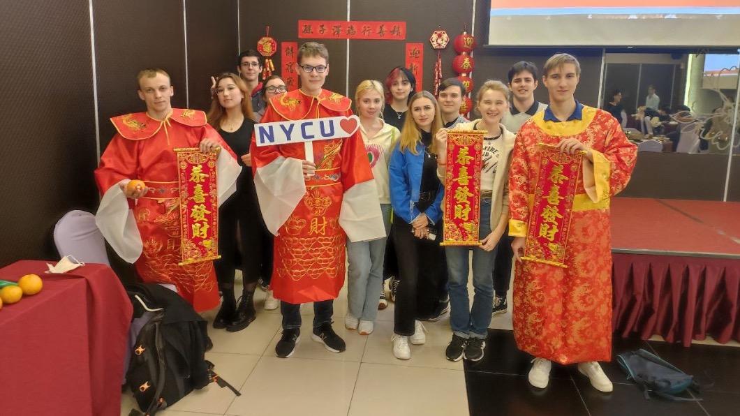 Mariia(右三)在2023過農曆年時，和同在陽明交通大學的烏克蘭學生，一起穿上應景服飾手拿春聯合影。圖／陽明交大提供