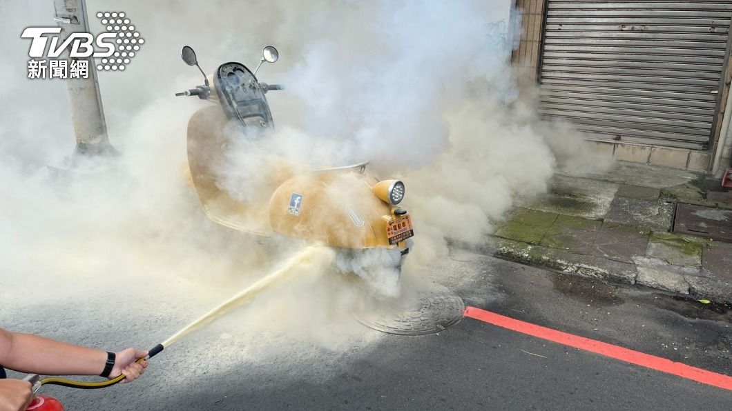 電動車突然竄出大量白煙,警員持滅火器撲救。(圖/TVBS)
