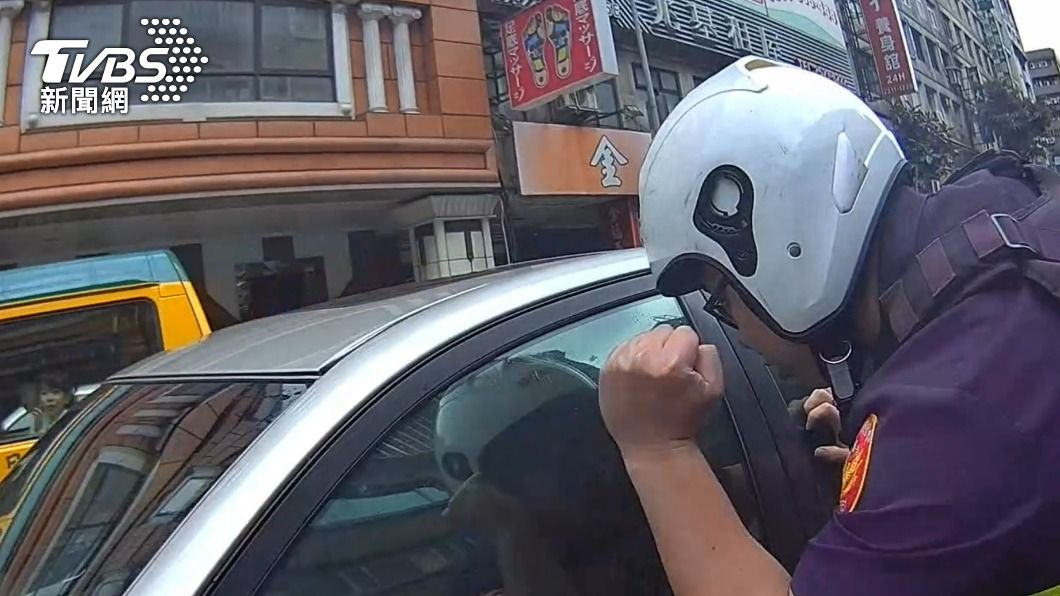 蘇男在車內昏睡，警員到場拍打車窗將他叫醒。（圖／TVBS）