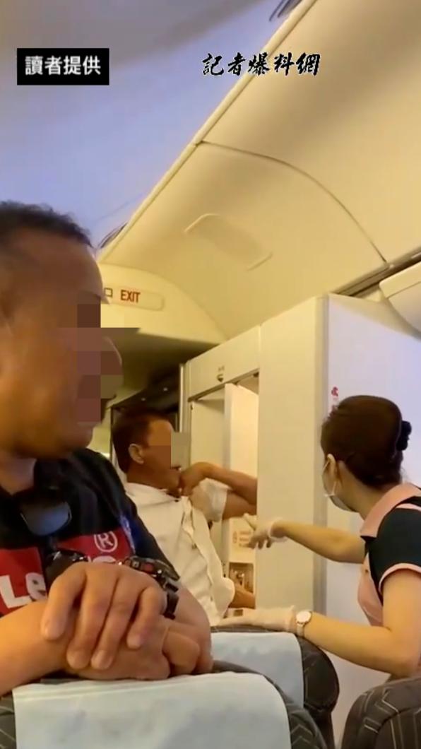 空服員奮勇上前隔開衝突旅客,動手旅客試圖掙脫。(圖/畫面翻攝 記者爆料網)