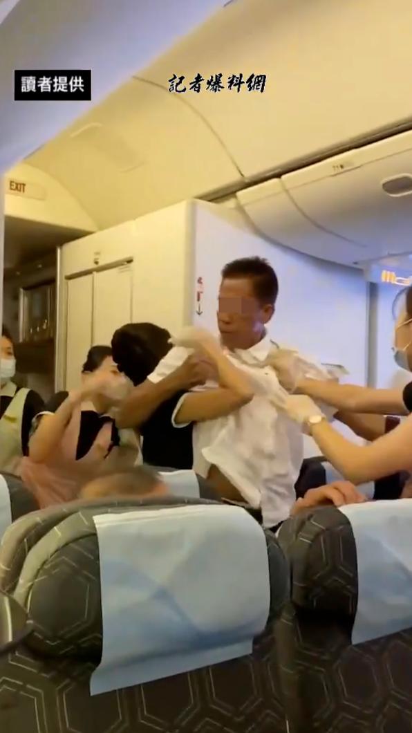 長榮航空機上爆發衝突,空服員英勇上前制止。(圖/畫面翻攝 記者爆料網)