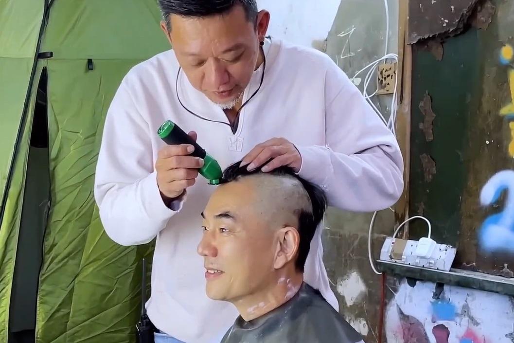 任賢齊（前）讓《九龍城寨之圍城》導演鄭保瑞剃頭。（圖／華映提供）
