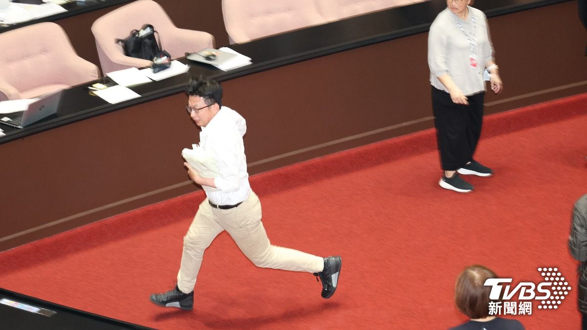 郭國文搶立法院秘書長的文件後跑出立法院。(圖/葉志明攝)