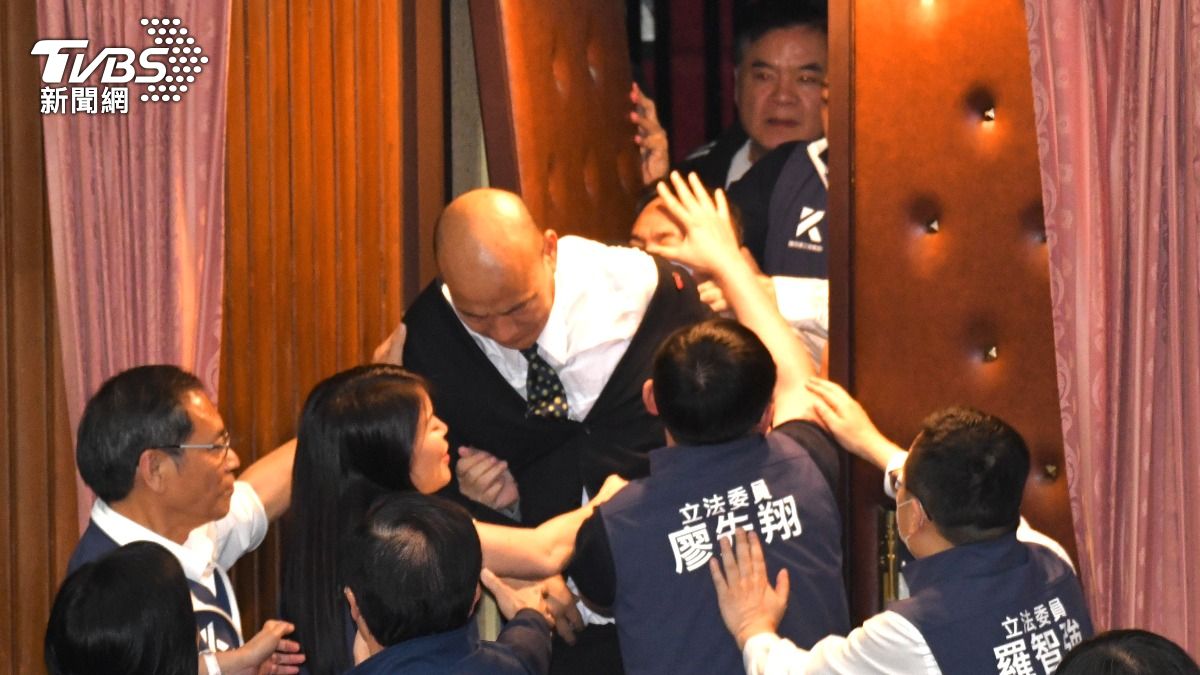韓國瑜受到激烈拉扯,西裝外套險被扒光。(圖/胡瑞麒攝)