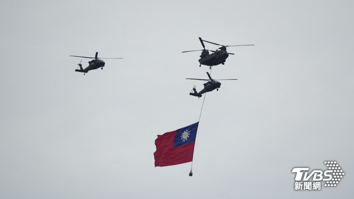 國軍直升機懸掛巨幅國旗通過會場上空。（圖／區國強攝）