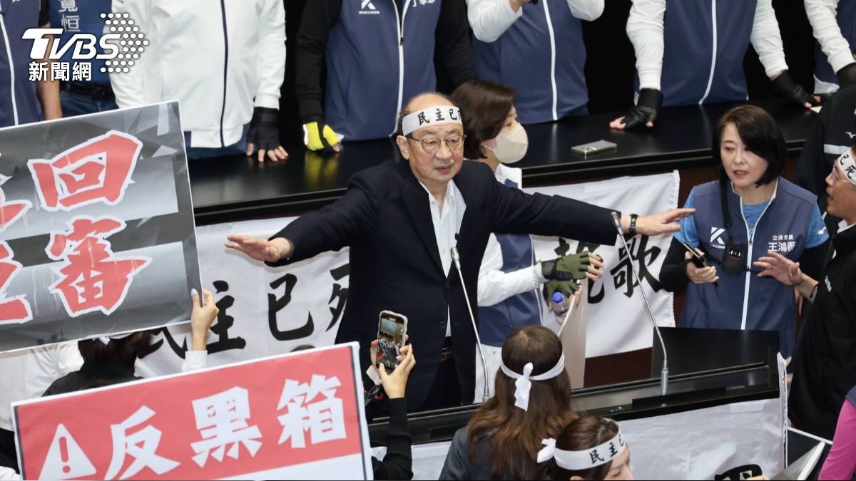 針對國會改革法案,綠委不斷提出表決,藍白立委邊舉手投票邊佔領主席台。(圖/葉志明攝)