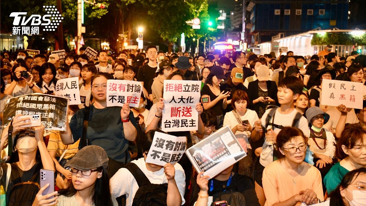 民眾舉起抗議海報。（圖／胡瑞麒攝）