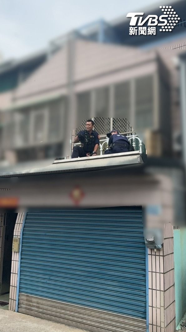 警方到場時陳姓男子站在1樓車庫頂上,情緒激動。(圖/TVBS)