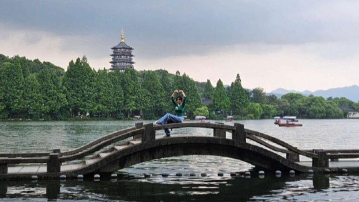 蔡依林遊覽西湖美景,開心坐在橋邊比愛心。(圖/翻攝自蔡依林IG)