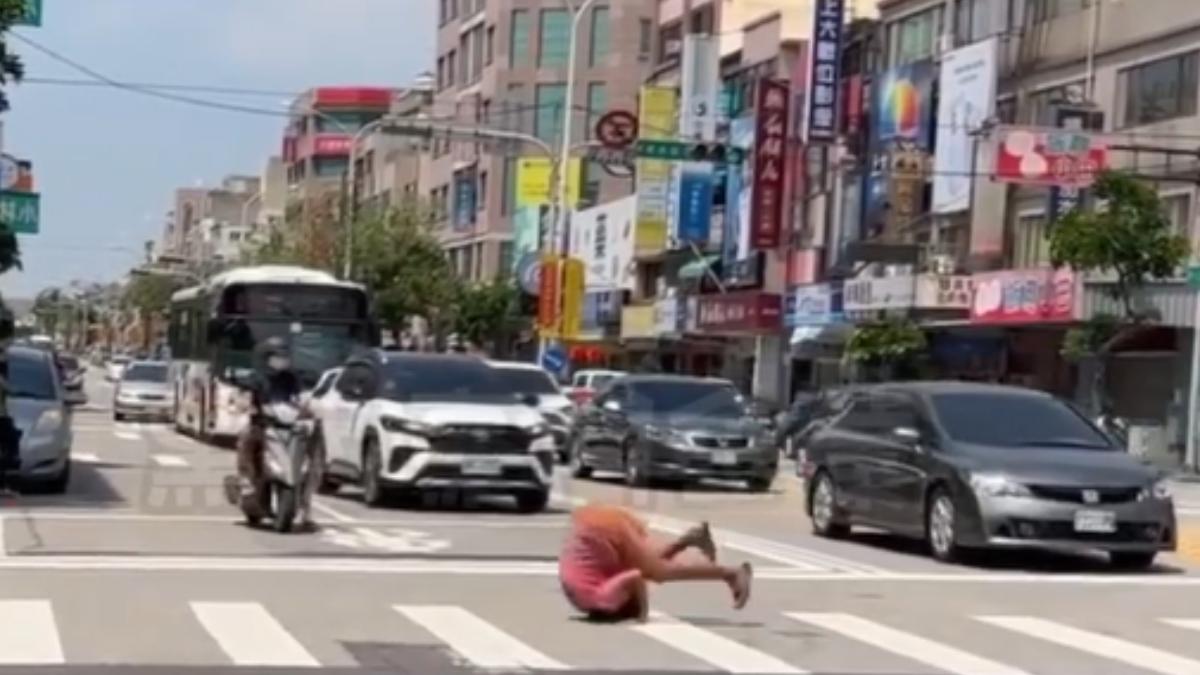 女子在馬路上翻滾。(圖/TVBS)