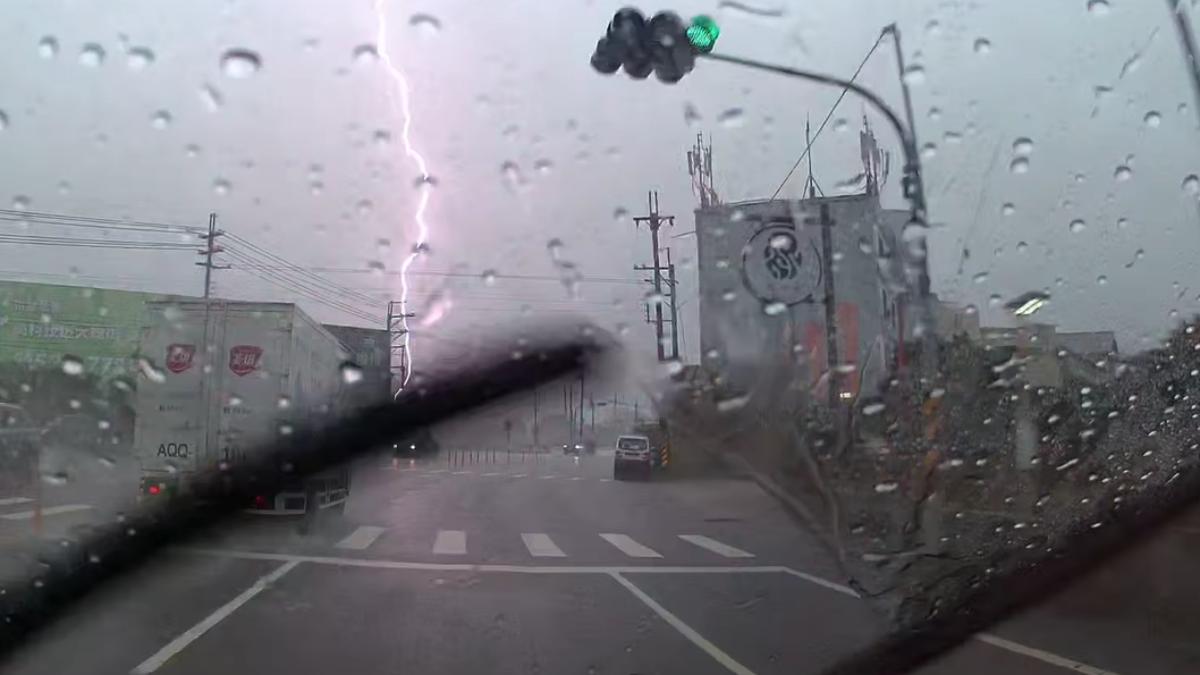 滂沱大雨中突然出現一道紫色雷電,貫穿了天空。(圖/翻攝自台南大小事)